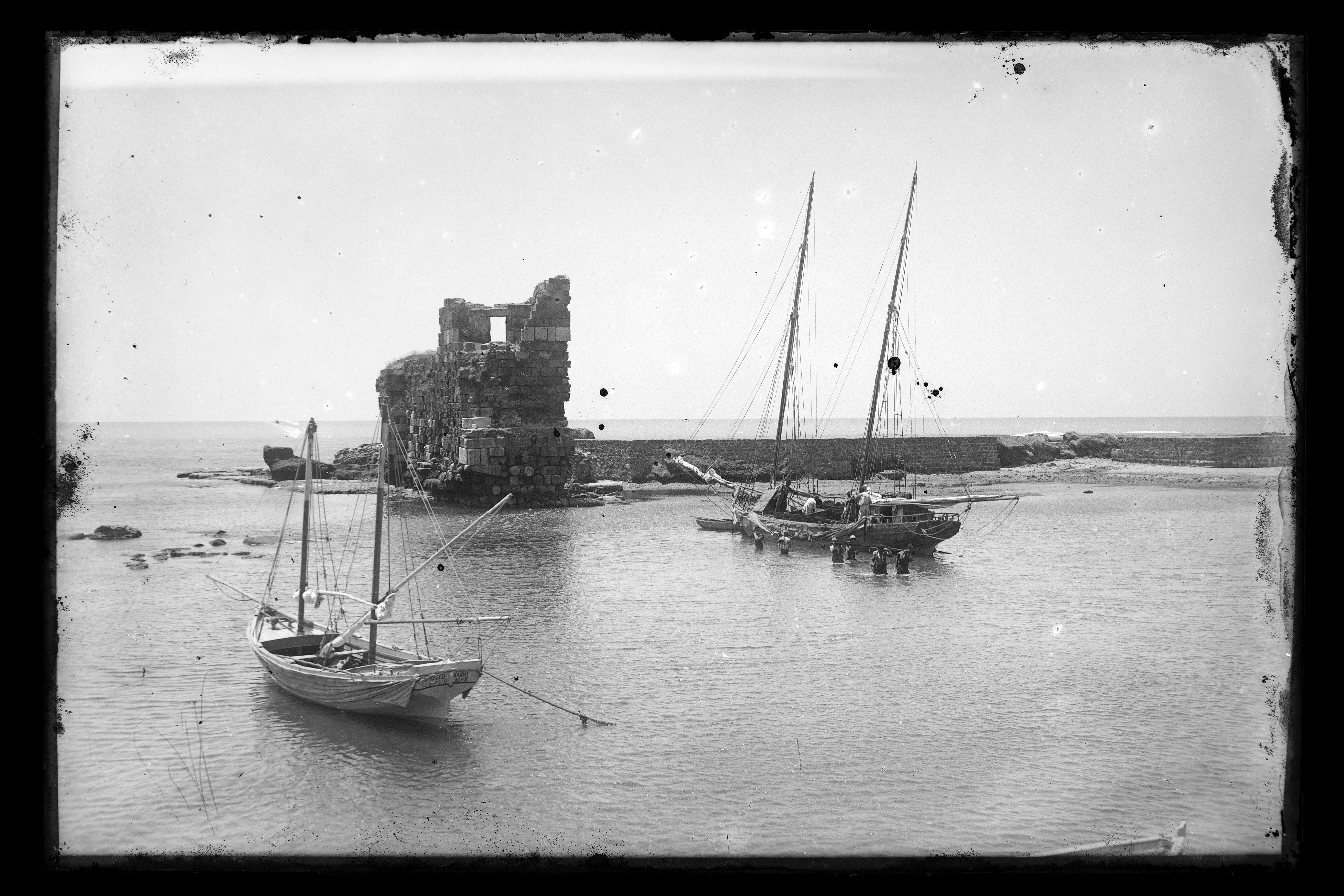 Historic photograph of boats beside a coastal ruin in Lebanon